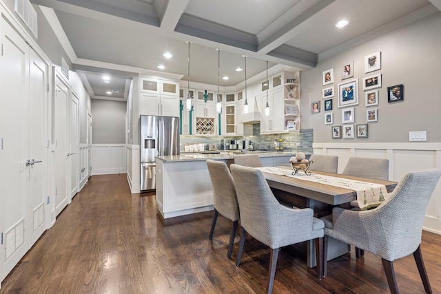 dining room with beamed ceiling, crown molding, and dark hardwood / wood-style flooring