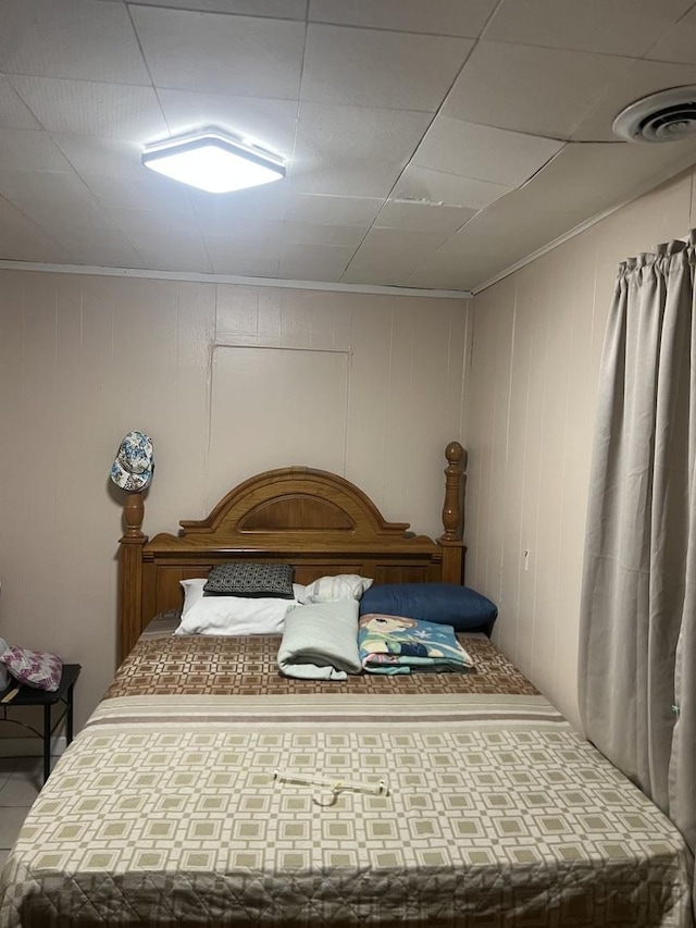 bedroom with wooden walls and ornamental molding