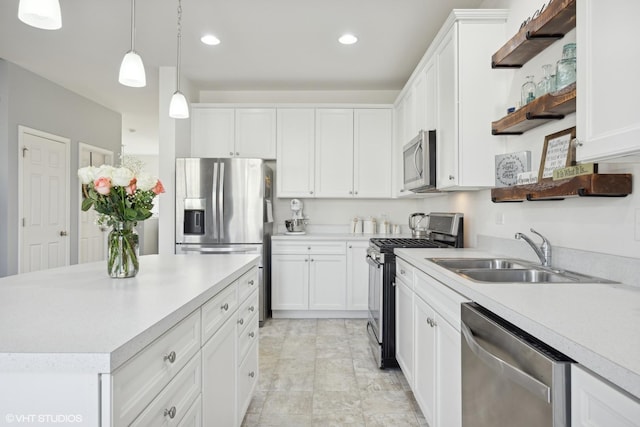 kitchen with sink, stainless steel appliances, a center island, white cabinets, and decorative light fixtures