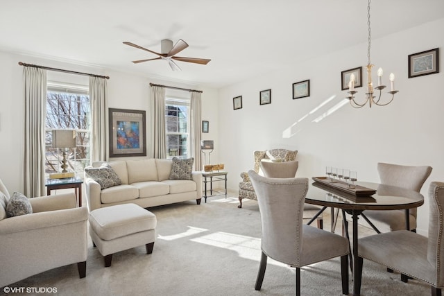 living room featuring ceiling fan with notable chandelier and light carpet