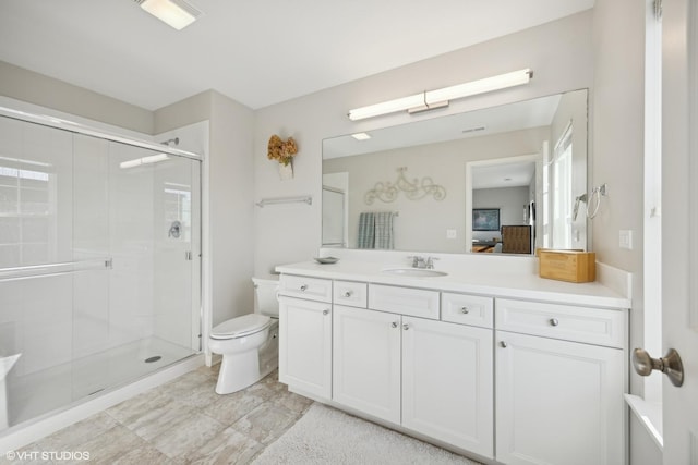 bathroom with vanity, toilet, and a shower with shower door