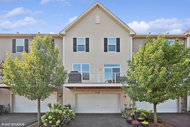 view of front of house with a garage, a balcony, and central AC