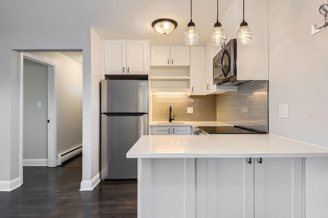 kitchen featuring decorative light fixtures, stainless steel fridge, white cabinets, and baseboard heating