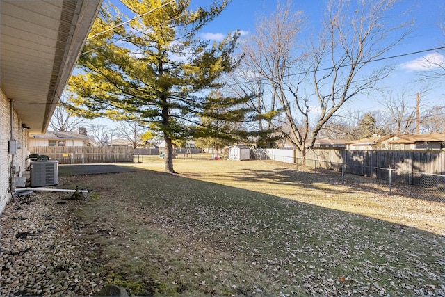 view of yard with an outbuilding, cooling unit, a storage shed, and a fenced backyard