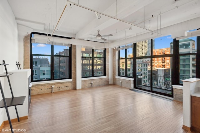 unfurnished sunroom featuring plenty of natural light, rail lighting, and ceiling fan