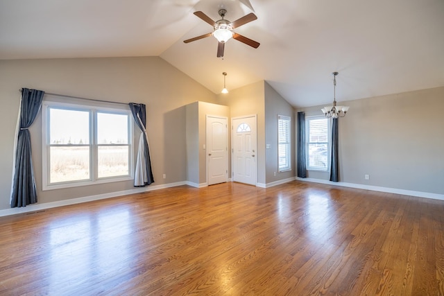 unfurnished living room with wood-type flooring, vaulted ceiling, and ceiling fan with notable chandelier