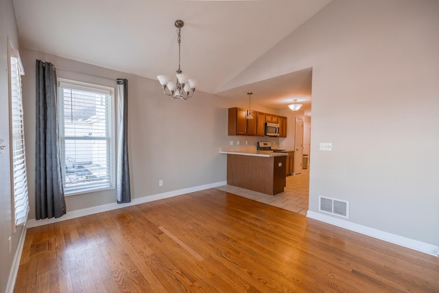 interior space featuring vaulted ceiling, a chandelier, and light wood-type flooring