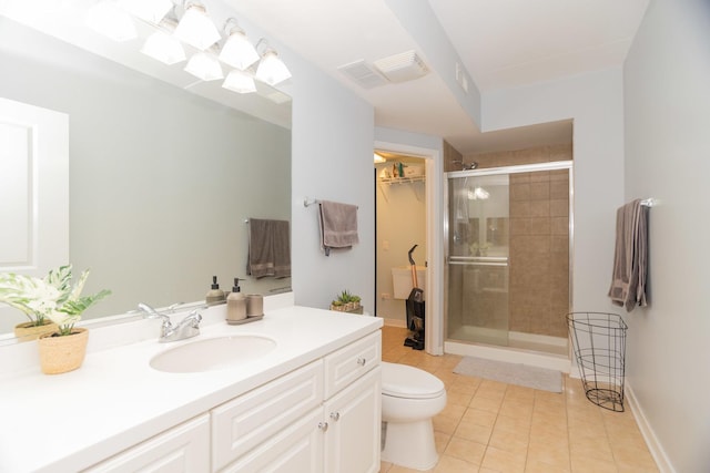 bathroom featuring tile patterned flooring, vanity, a shower with shower door, and toilet