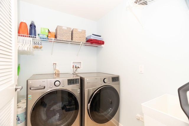 laundry area featuring washing machine and clothes dryer and sink