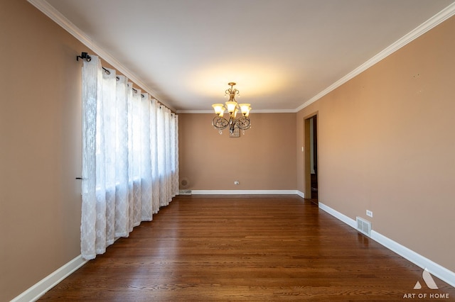 spare room featuring dark hardwood / wood-style flooring, crown molding, and a chandelier