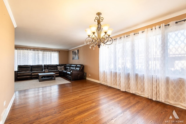 living room with hardwood / wood-style flooring, crown molding, and a notable chandelier