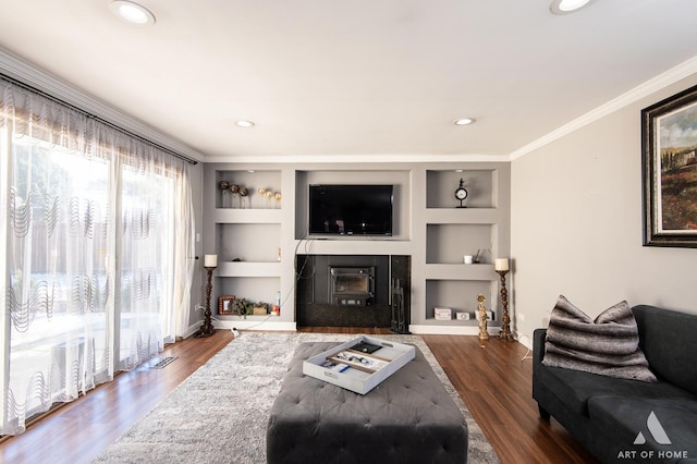 living room featuring crown molding, dark wood-type flooring, and built in shelves