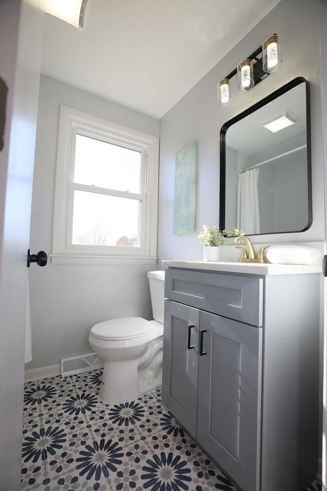 bathroom with a shower with curtain, tile patterned floors, toilet, and vanity