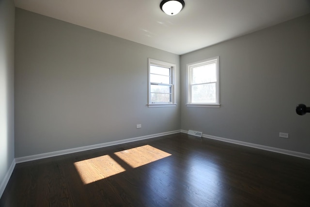 empty room with dark hardwood / wood-style flooring