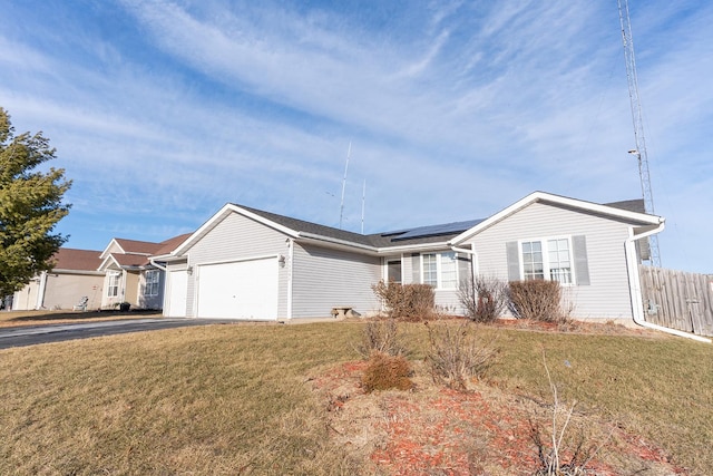 ranch-style home featuring a garage, a front lawn, and solar panels