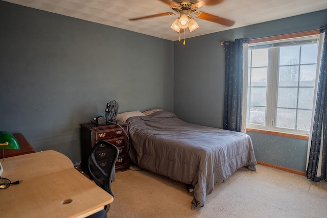 bedroom featuring multiple windows, light colored carpet, and ceiling fan