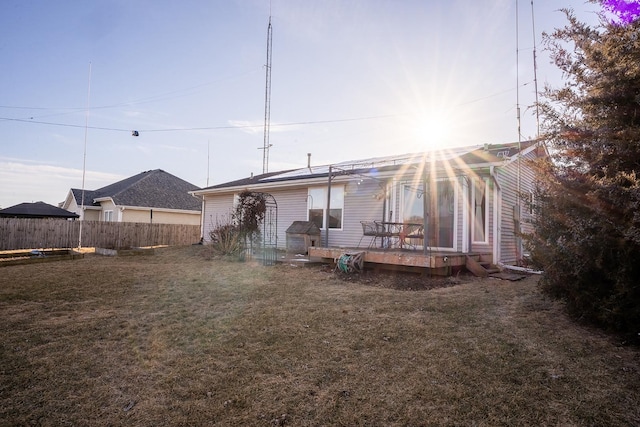 rear view of property featuring a wooden deck and a yard