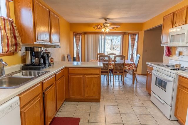 kitchen featuring white appliances, kitchen peninsula, sink, and light tile patterned floors