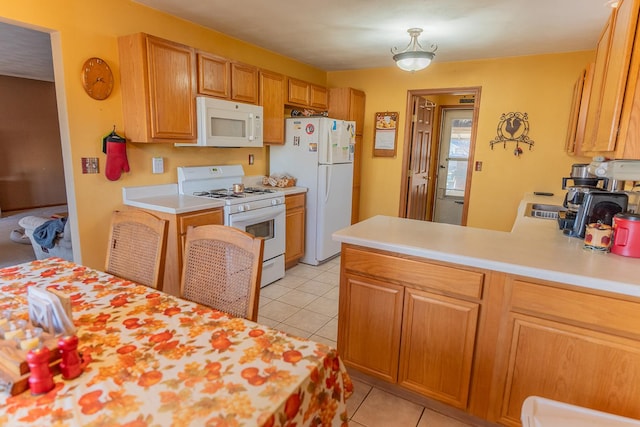 kitchen featuring light tile patterned floors, white appliances, and kitchen peninsula