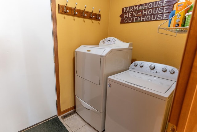 washroom with light tile patterned floors and washing machine and clothes dryer