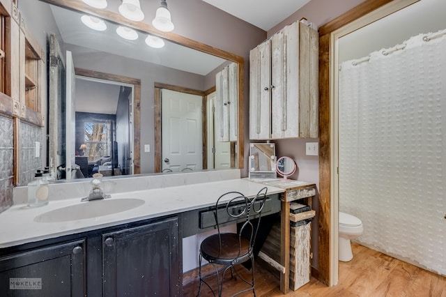 bathroom featuring wood-type flooring, toilet, and vanity