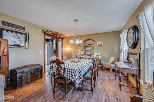 dining room with hardwood / wood-style flooring and an inviting chandelier