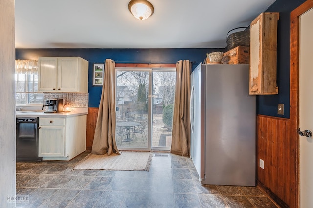 kitchen with white cabinetry, plenty of natural light, stainless steel refrigerator, and black dishwasher