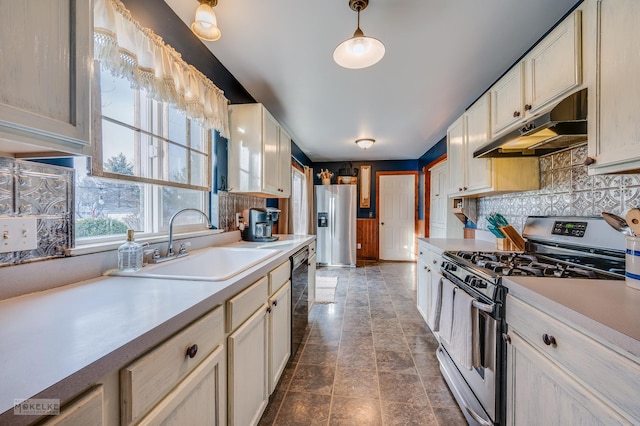 kitchen featuring stainless steel appliances, decorative light fixtures, sink, and backsplash