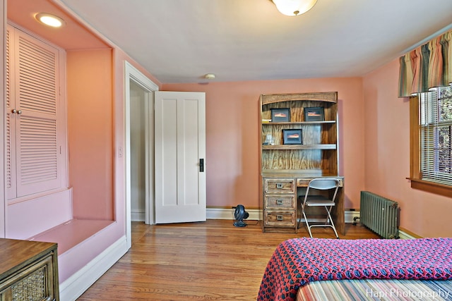 bedroom featuring radiator and light wood-type flooring