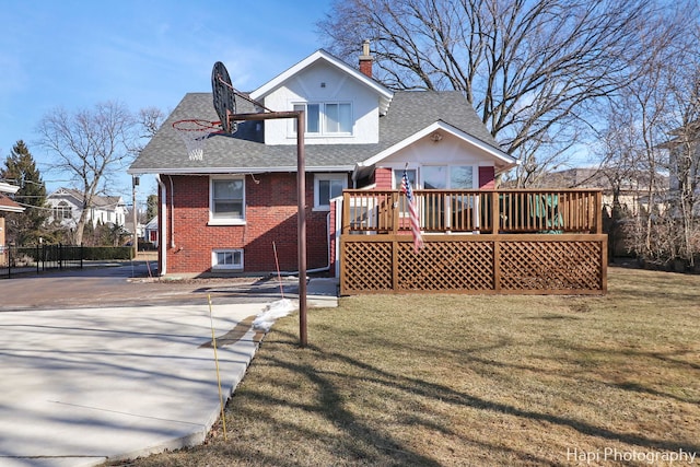 rear view of house featuring a deck and a lawn