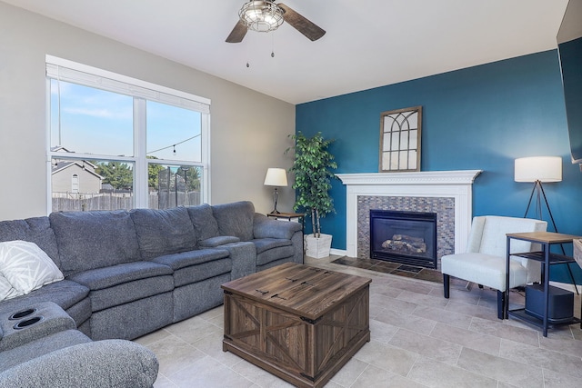 living room featuring a tiled fireplace and ceiling fan