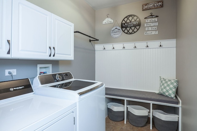 washroom featuring tile patterned flooring, washer and clothes dryer, and cabinets