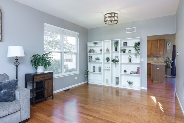 living area with a notable chandelier and light wood-type flooring