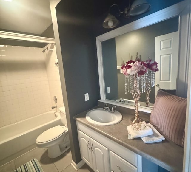 full bathroom featuring tile patterned flooring, vanity, tiled shower / bath combo, and toilet