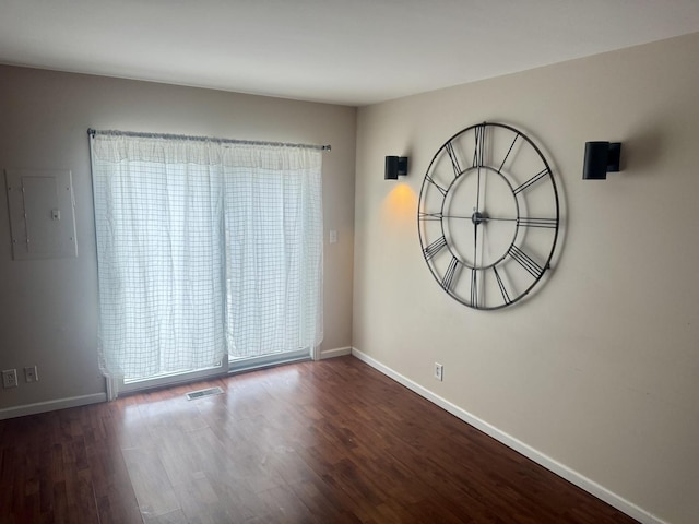 spare room with dark wood-type flooring and electric panel