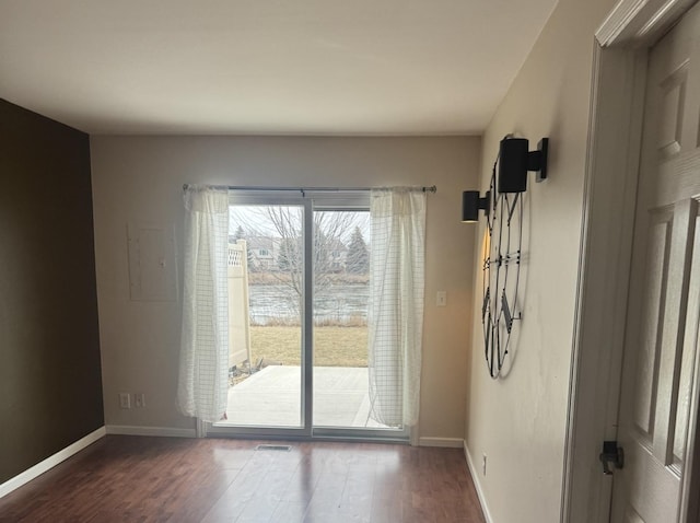 doorway to outside featuring dark hardwood / wood-style floors and electric panel