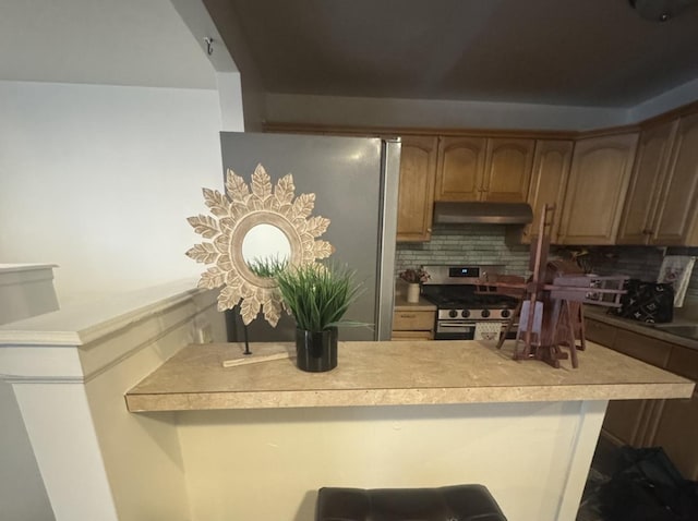 kitchen featuring stainless steel range with gas stovetop, kitchen peninsula, and decorative backsplash