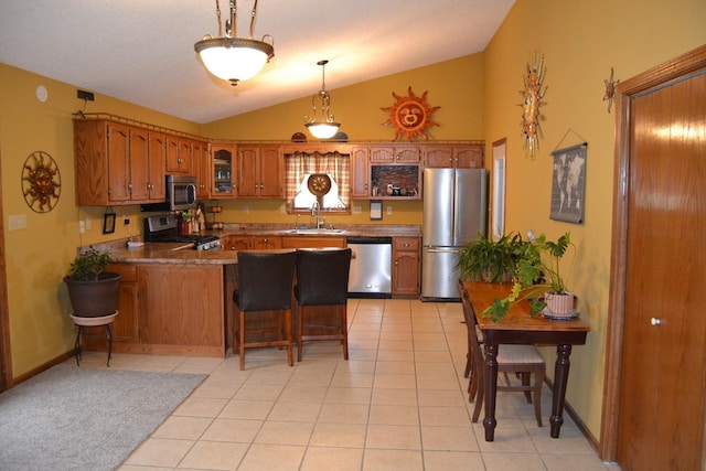 kitchen with sink, a breakfast bar area, light tile patterned floors, appliances with stainless steel finishes, and kitchen peninsula