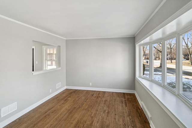unfurnished room featuring visible vents, dark wood-type flooring, baseboards, and crown molding