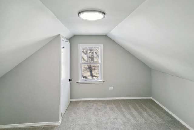 additional living space featuring lofted ceiling and light colored carpet