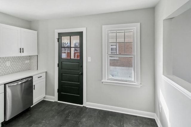kitchen featuring tasteful backsplash, stainless steel dishwasher, light countertops, baseboards, and white cabinets