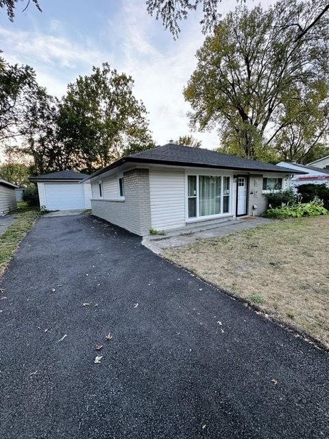 view of front of house with a garage and an outbuilding