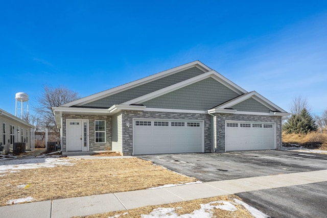 view of front of property featuring a garage and central air condition unit