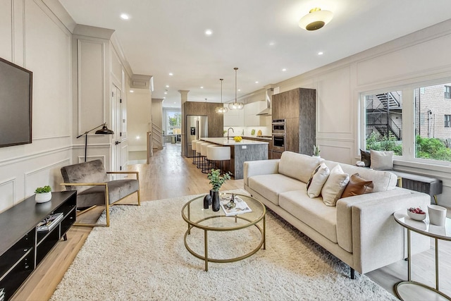 living room featuring crown molding, radiator, and light hardwood / wood-style flooring