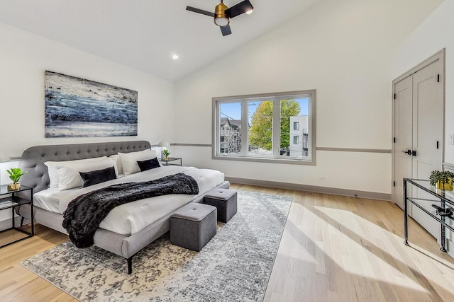 bedroom with light hardwood / wood-style flooring, high vaulted ceiling, and ceiling fan