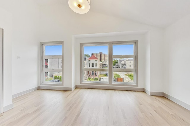 unfurnished living room with high vaulted ceiling and light wood-type flooring