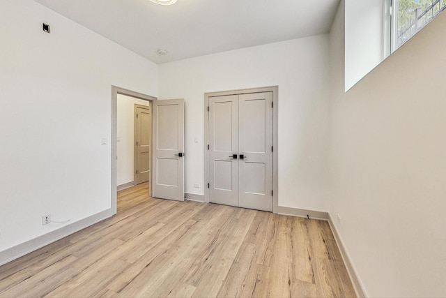 unfurnished bedroom featuring light hardwood / wood-style floors and a closet