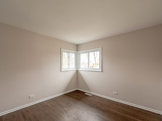 spare room with dark hardwood / wood-style flooring