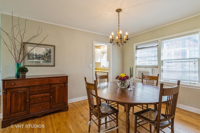 dining room featuring crown molding, sink, a chandelier, and light hardwood / wood-style floors