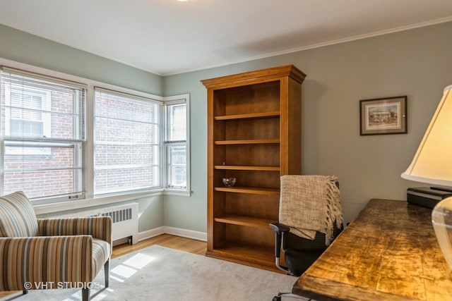 home office with crown molding, radiator, and light hardwood / wood-style floors